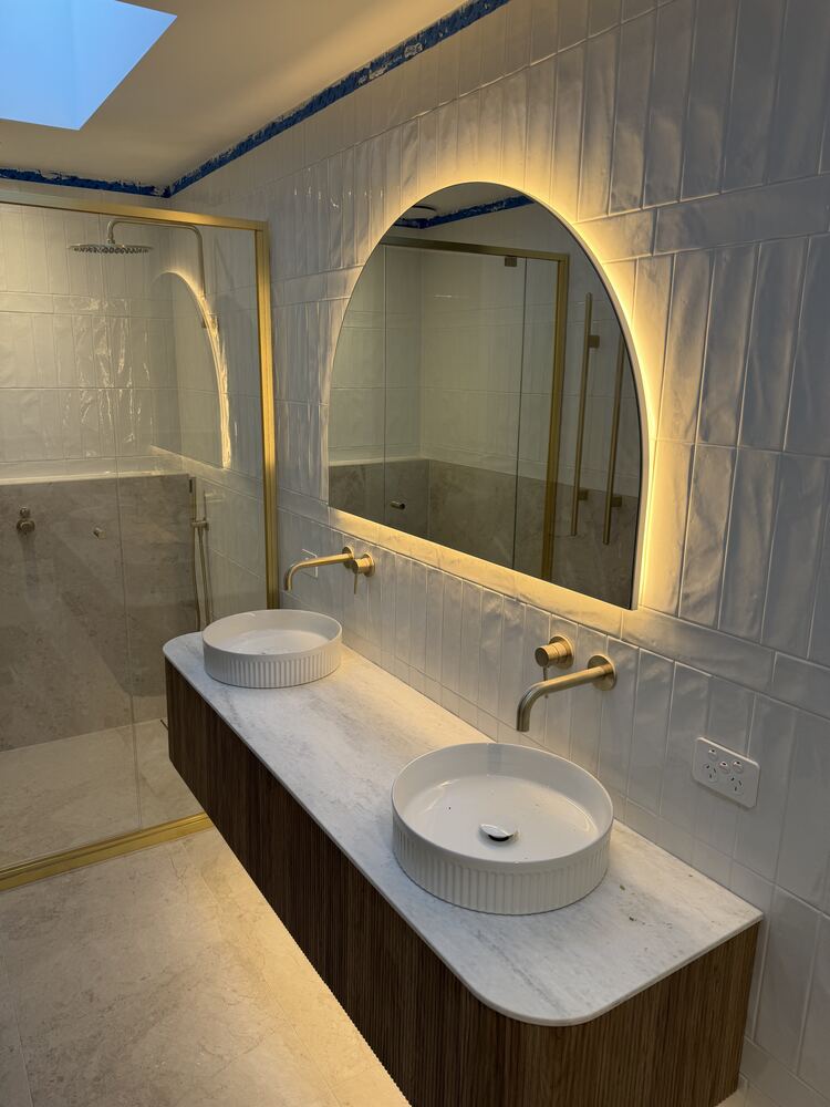 Bathroom vanity with backlit mirror and wall-mounted tapware wiring