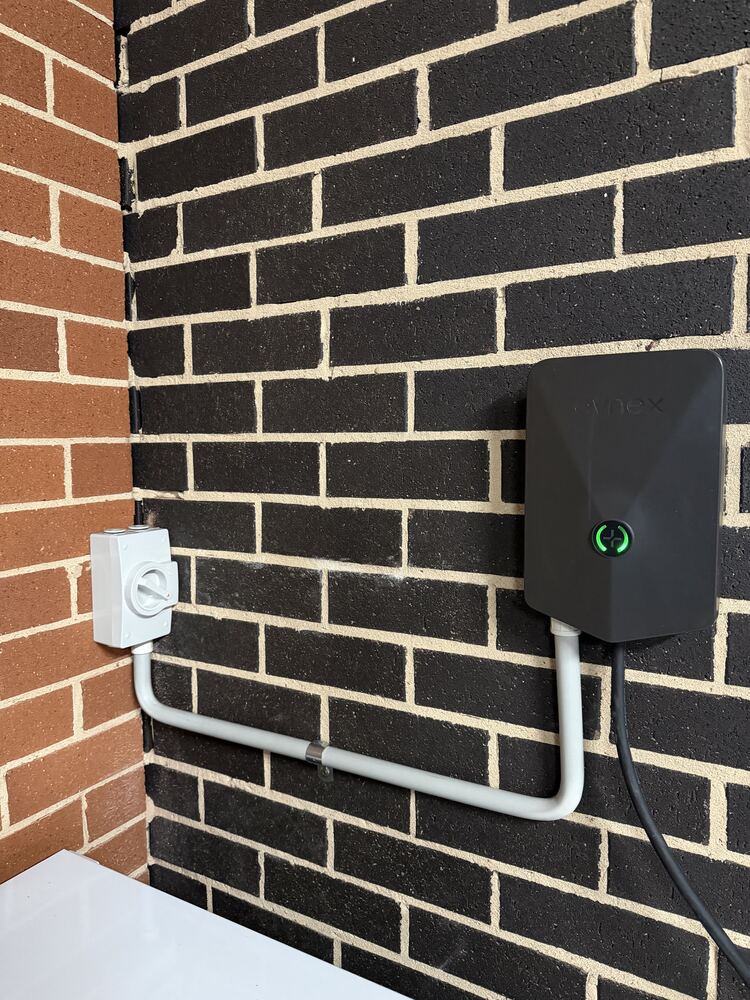 Evnex EV charger installed on a brick exterior wall