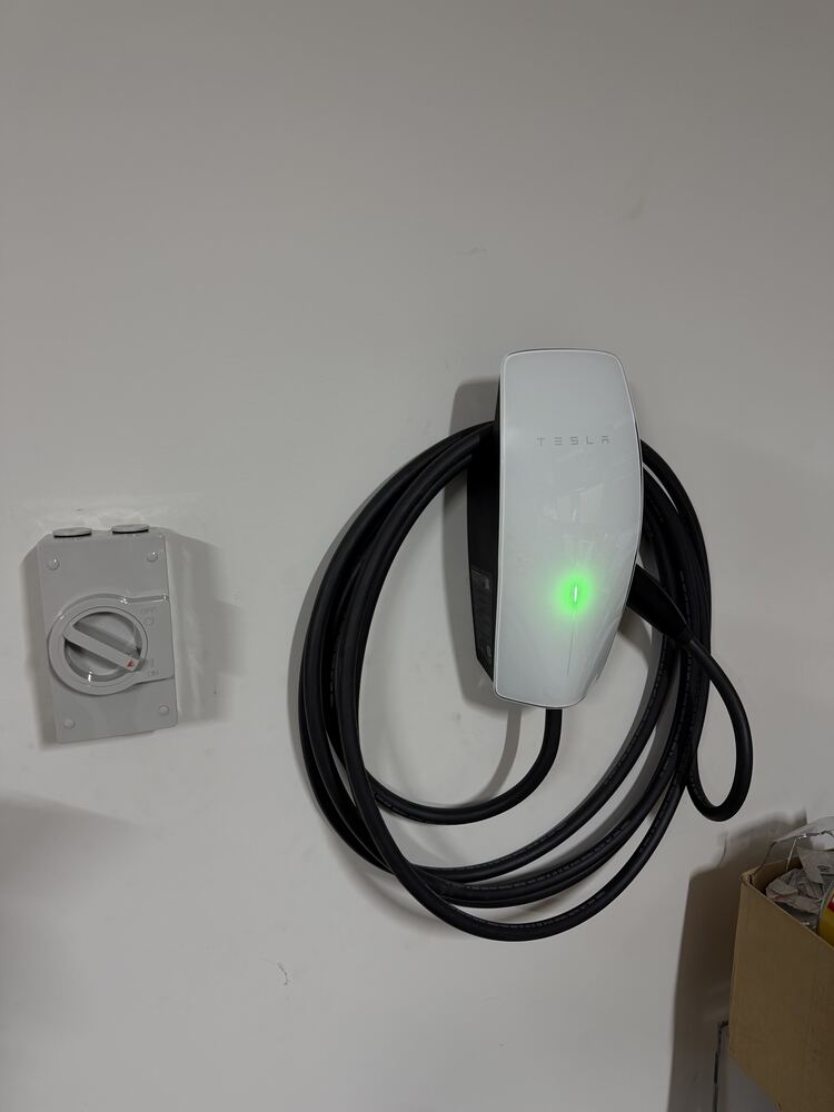 Tesla Wall Connector EV charger installed on a garage wall