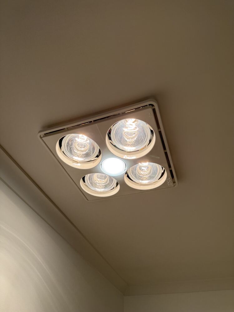 Bathroom heat lamp and exhaust fan unit installed in ceiling